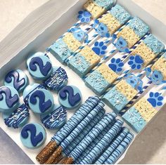 a box filled with blue and white cookies next to crackers in the shape of numbers