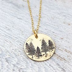 "Tree Necklace - Forest Necklace - Gift for Her - Stocking Stuffer - Winter Birthday Necklace - Pine Tree Necklace - Evergreen Jewelry 5/8\" brass disk is stamped with little pine trees, and given a rustic finish. It hangs from a dainty gold filled cable chain." Nature-inspired Round Necklace For Anniversary, Handmade Green Necklaces For Birthday Gift, Handmade Green Necklace For Birthday Gift, Green Engraved Necklace For Gift, Nature-inspired Round Anniversary Necklaces, Personalized Green Charm Necklace For Gift, Nature-inspired Round Anniversary Necklace, Personalized Nature-inspired Charm Necklace For Gifts, Handmade Round Charm Necklace For Birthday