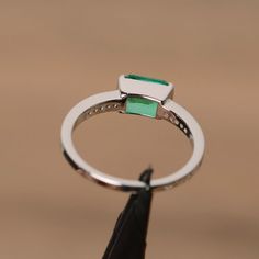 It is lab grown emerald ring, the main stone is about 5mm*7mm, emerald cut, weight about 0.85 carats.The basic metal is sterling silver and plated with rhodium.To change the metal to a solid gold (white/rose) or platinum is also available, please ask for a quotation if you want.You can also go to my shop Home for more elegant rings: https://www.etsy.com/shop/godjewelry?ref=hdr_shop_menuEmerald is May birthstone.More emerald rings:https://www.etsy.com/shop/godjewelry?ref=hdr_shop_menu&section May Birthstone Ring With Emerald Cut And Halo Setting, Solitaire Emerald Cut Emerald Promise Ring, Emerald Cut Solitaire Emerald Promise Ring, Emerald Cut Emerald Ring With Halo Setting, May Birthstone Emerald Cut Emerald Ring, Green Emerald Cut Birthstone Ring With Halo Setting, Emerald Cut Green Birthstone Ring With Halo Setting, Emerald Cut Diamond Ring For May Birthstone, Square Cut Emerald Ring In White Gold