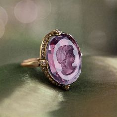 "As soon as this charming ring comes into your possession, will draw attention and speculation about its history--you'll have to invent something fascinating to tell them... We set the intaglio into a delicate, yet sizeable ring design with an open bezel and under-gallery, bordered with tiny glimmering smoke crystal. Top of ring: 1\" x 0.75\" x 0.25\"   Sizes available: 7, 8, 9 and 10  Cast in bronze and made in our Los Angeles studio. Arrives ready to gift. Rings are cast individually for each Intaglio Ring, Purple Stone Ring, Blue Amethyst, Locket Bracelet, Blue Stone Ring, Antique Ring, Cameo Ring, Silver Jewels, Ring Antique