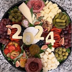 a platter filled with cheeses, meats and olives for new year's eve