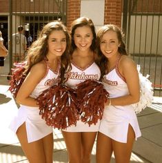 three girls in cheerleader outfits posing for the camera