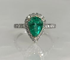 Emerald Ring Vintage, Emerald Diamond Ring, Emerald East West Ring, Emerald Engagement Ring, Emerald Cut Emerald Ring, Emerald Jewelry 18k A striking vibrant emerald ring featuring a pear shaped center stone weighing 1.44 carats accented by a halo of diamonds weighing 0.47 carats which continue along the band set in unique two toned solid 18k white and yellow gold. *Ring size: US 6 3/4 *Ring weight: 3.64 Grams *Center stone dimension: 9X6.1mm Fine Jewelry Emerald Ring With Halo Design, Gia Certified Pear-shaped Emerald Ring, Gia Certified Green Pear-shaped Rings, Fine Jewelry Emerald Ring With Brilliant Pear-shaped Cut, Brilliant Cut Pear-shaped Emerald Ring, Pear-shaped Emerald Ring With Brilliant Cut, Fine Jewelry Emerald Ring With Halo Setting, Pear-shaped, Pear-shaped Emerald Ring With Halo Setting, Fine Jewelry Emerald Ring With Halo Setting