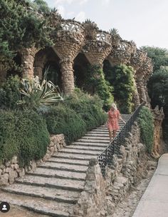 a woman walking up some steps in front of trees