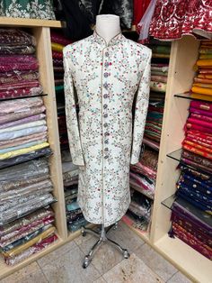 Men's Ivory sherwani with all-over blue and red thread embroidery ( French knot stitch with zardozi work). This sherwani is an easy to match with most lehengas Comes with Ivory churidars. Crafted with a collar neckline, full sleeves, and front button closure. Occasion: Can be worn to events like Wedding WASH CARE INSTRUCTIONS - Please Dry clean only when it is applicable. Slight color variation is possible due to digital photography. Traditional Sherwani With Intricate Embroidery For Transitional Season, Traditional Raw Silk Sherwani With Intricate Embroidery, Transitional Season Embroidered Raw Silk Sherwani, Traditional Cream Sherwani With Embroidery, Transitional Raw Silk Sherwani With Intricate Embroidery, Traditional Cream Embroidered Sherwani, Raw Silk Bandhgala With Intricate Embroidery For Traditional Ceremonies, Traditional Embroidered Cream Sherwani, Semi-stitched Embroidered Raw Silk Sherwani