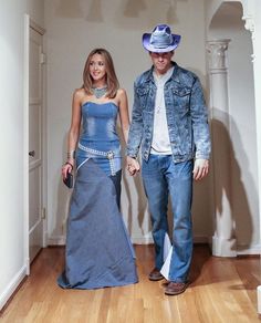 a man and woman are walking down the hall together wearing cowboy hats on their heads