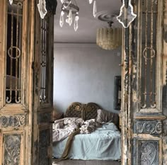 an open door leading into a bedroom with a bed and chandelier