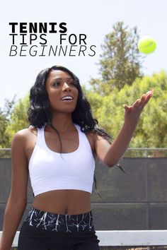 a woman in white top and black shorts holding a tennis ball with her right hand