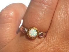 Opal Ring - Gold and Silver Ring - White Opal Pink Zircon Ring - Stackable Ring - Fire Opal Ring - 24k Gold - Opal Engagement Ring - Pink Zircon - Pink Ring. A lovely Opal (measures about 7 mm with the gold bezel around), with lots of pinks greens and more, is set in 24k solid gold, with small faceted pink Zircon (3 mm each) set in sterling silver on each side. The band is half round, hammered sterling silver (3 mm wide). Made to order in your size (Please pick your ring size in the drop-down me Pink Opal Gemstone Ring For Anniversary, Pink Opal Ring With Accent Stones As Gift, Pink Opal Round Ring For Anniversary, Pink Opal Rings With Gemstone, Pink Opal Rings For Anniversary, Pink Opal Gemstone Rings, Pink Multi-stone Birthstone Ring, Anniversary Pink Opal Round Ring, Gold Opal Engagement Ring