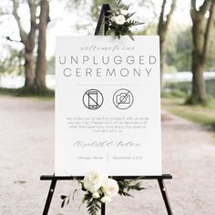 an unplugged ceremony sign with flowers on it