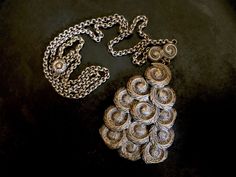 "This pendant of machine stamped feathery swirls of silver plated brass is attached to a pretty chain with details that complement the pendant. It is unsigned and I imagine it to be from before mid century, but I can't be sure. The quality is good as is the condition with just slight surface wear to the pendant. The necklace chain is 24\" long. The pendant is 2 1/2\" long X 1. 3/4\" wide." Puka Shell Necklace, Puka Shell, Butterfly Bracelet, Ring Photos, Shell Necklaces, Necklace Chain, Vintage Necklace, Chains Necklace, Silver Plate