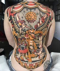 the back of a woman's body with tattoos on it and an image of two cats