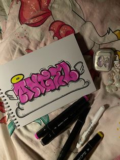 an open notebook sitting on top of a bed covered in graffiti