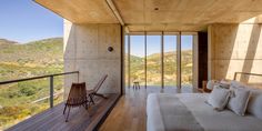 a bedroom with a large bed sitting on top of a wooden floor next to a balcony