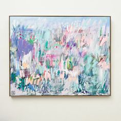 an abstract painting hangs on the wall in front of a white wall with blue, pink and green colors