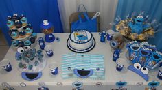 a table topped with blue and white cakes and cupcakes on top of it