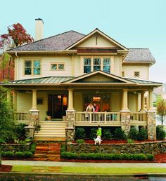 two people are standing on the front porch of a large house with stone steps leading up to it