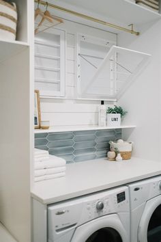 a washer and dryer in a white laundry room with blue tile backsplash