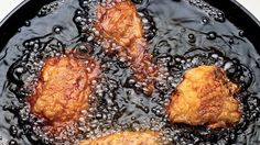 three fried meats are being cooked in a frying pan with oil on the side