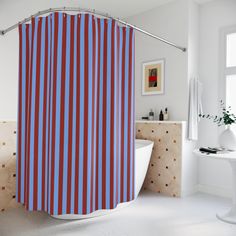 a red and blue striped shower curtain in a white bathroom with a bathtub next to it