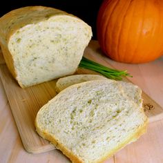 two slices of bread sitting on top of a cutting board next to an orange pumpkin