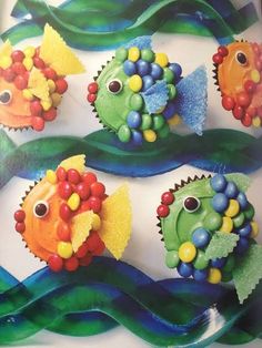 the cupcakes are shaped like fish and have colorful decorations on them