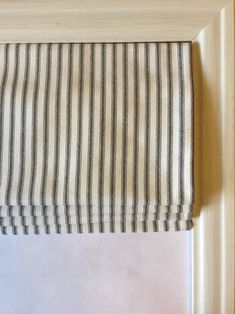 a black and white striped curtain hanging from a wooden frame