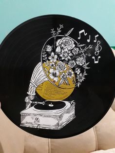 a record player with flowers and music notes on it's side sitting on a chair