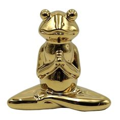 a gold frog statue sitting on top of a yoga mat in front of a white background