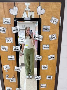 a woman standing in front of a door decorated with magnets and paper cutouts