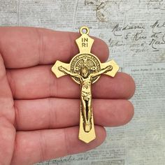 You will receive 1 - Extra Large St Benedict Crucifix Cross Pendant in Antique Gold Pewter 70x41x5mm by TIJC. These charms are a quality Pewter for all your jewelry and crafting projects! - (1) Christian Pendant - 70x41x5mm ( 25.4mm = 1 inch ) - Quality Pewter - Item # SP1675 Use to Make Mens Crucifix Necklace Gold Crucifix Necklace All Items will come as shown in a poly bag! WE ARE LOCATED IN TEXAS. WHICH MEANS YOU RECEIVE ITEMS QUICKLY IF IN THE U.S! WE ALSO SHIP INTERNATIONALLY All items are Gold Crucifix Necklace, St Benedict Cross, Crucifix Necklace, Jesus Christ Artwork, St Benedict, Saint Benedict, Police Badge, Cross Jewelry, Poly Bags