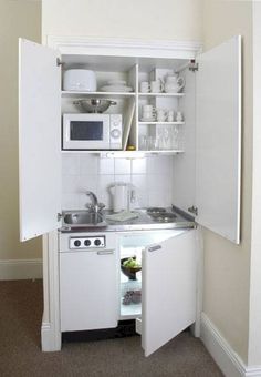 a small kitchen with white cabinets and appliances on the appliance's page