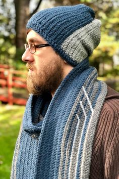 a man wearing a blue and gray scarf with a knitted hat on his head