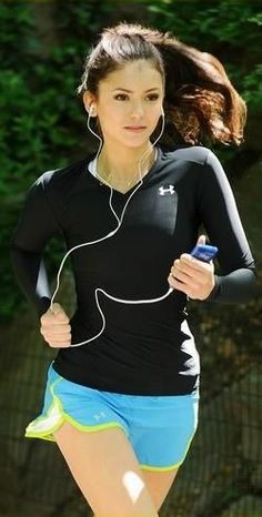 a woman running with earphones on her ears and headphones in her ears,