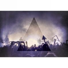 a group of people holding up flags in front of a triangle shaped pyramid at a concert