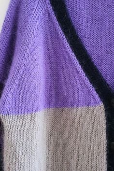 a purple and grey sweater with black buttons