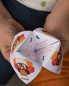 a person holding up a paper turkey origami