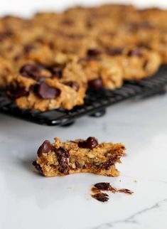 chocolate chip oatmeal cookies on a cooling rack next to a half eaten cookie