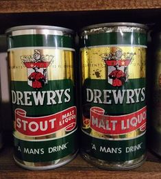 three cans of beer sitting on top of a wooden shelf