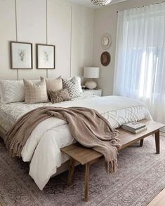 a bedroom with a large bed covered in blankets and throw pillows on top of it