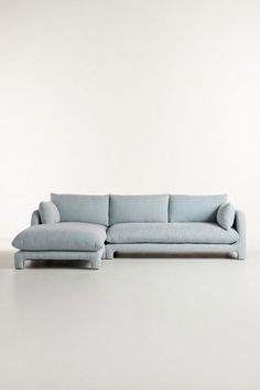 a blue couch sitting on top of a white floor