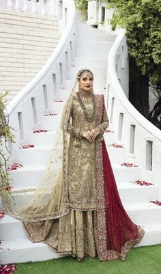 a woman standing in front of some stairs wearing a dress and headpiece with flowers on it