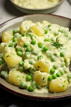 a bowl filled with potatoes and peas next to another bowl full of mashed potatoes