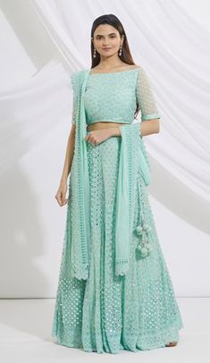 Turquoise blue lehenga with floral embroidered motifs, paired with embroidered blouse and dupatta, featuring a boat neckline, elbow-length sleeves, cutwork detail, and side tassel tie-up. Turquoise Lehenga, Blue Lehenga