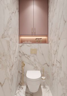 a white toilet sitting inside of a bathroom next to a pink cabinet with gold handles