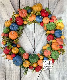 a wreath made out of fake pumpkins on a white wooden background with the words pink floyd farms written below it