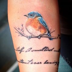 a small blue bird sitting on top of a tree branch with words written below it