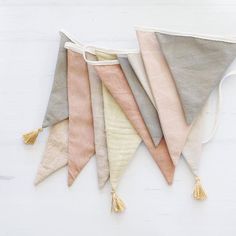 five different colored pennants with tassels hanging from the side on a white background