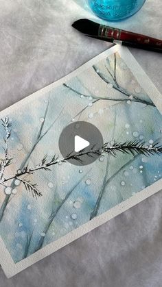 a watercolor painting of branches and snow with a blue vase in the foreground