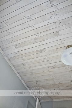 a white sink sitting under a wooden ceiling